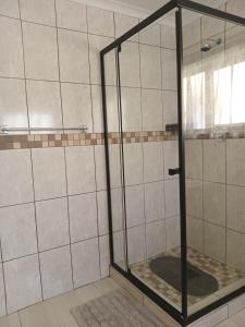 a shower with a glass door in a bathroom at Scholtz Self-catering Accommodation in Lüderitz