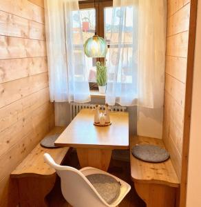 ein kleines Zimmer mit einem Tisch, Stühlen und einem Fenster in der Unterkunft Apartmenthaus Der Johanneshof - tolle Lage nah am See in Schliersee