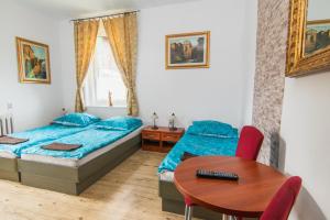 1 Schlafzimmer mit 2 Betten und einem Tisch in der Unterkunft Willa Dunajec in Kudowa-Zdrój
