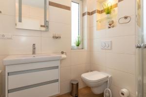 a white bathroom with a sink and a toilet at Yachthafenresidenz in Kühlungsborn +33 photos