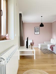 a white living room with a couch and a table at Don Balkan Араrtamen Roza in Vrnjačka Banja