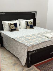 ein Bett mit einer schwarzen und weißen Bettdecke und Kissen in der Unterkunft The Rukmani Homestay & Garden in Udaipur