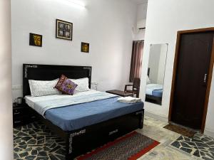 Schlafzimmer mit einem Bett und einem Spiegel in der Unterkunft The Rukmani Homestay & Garden in Udaipur