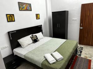 a bedroom with a bed with two towels on it at The Rukmani Homestay & Garden in Udaipur +43 photos