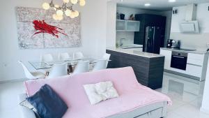 een woonkamer met een roze bank en een keuken bij Villa with pool Marina Villamartin in Villamartin