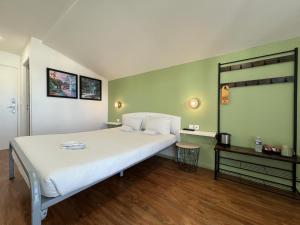 Un dormitorio con una gran cama blanca y una mesa en St Christopher's Inn Paris - Canal, en París