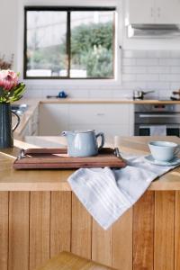 a kitchen with a table with a tea pot on it at The Sandy Sister in Dodges Ferry