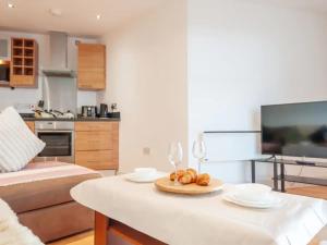 a living room with a table with a plate of food at Pass the Keys Panoramic Serenity - Summer Bliss - Leeds Dock in Leeds