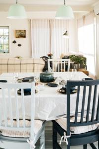 a dining room with a white table and chairs at The Sandy Sister in Dodges Ferry