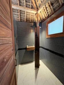 a bathroom with a shower with a window and a door at TIKI Beach Club & Resort in Bwejuu