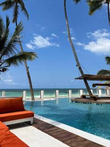 TIKI Beach Club & Resort في بويجو: مسبح فيه كرسي والنخيل