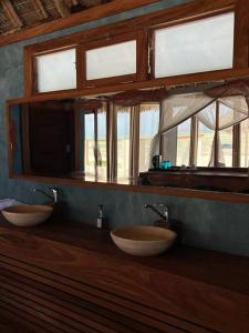 two sinks in a bathroom with two windows at TIKI Beach Club & Resort in Bwejuu