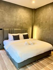 a bedroom with a large bed with two towels on it at NADON VILLA in Ban Choko