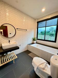 a bathroom with a tub and a toilet and a sink at NADON VILLA in Ban Choko