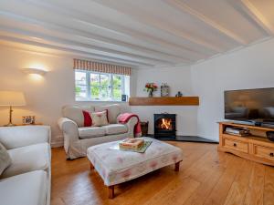 a living room with a couch and a fireplace at 3 bed property in Bude 53607 in Jacobstow