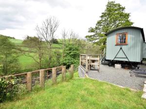 a green shed with a wooden fence and grass at 1 Bed in Llanidloes 56492 in Van