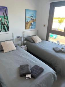 een slaapkamer met twee bedden met handdoeken erop bij Lamar - Pilar de la Horadada in Pilar de la Horadada