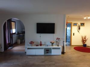 sala de estar con TV en una pared blanca en NEU! FeWo Maya mit Sauna, en Hagen im Bremischen