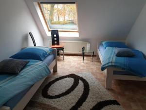 1 dormitorio con 2 camas, ventana y alfombra en NEU! FeWo Maya mit Sauna, en Hagen im Bremischen