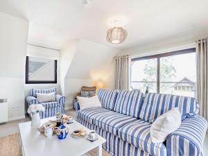 una sala de estar con sofás de rayas azules y blancas y una mesa. en 4 bed property in Whiting Bay Isle of Arran 76168, en Whiting Bay