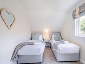 two twin beds in a small room with a heart mirror at 4 bed property in Whiting Bay Isle of Arran 76168 in Whiting Bay