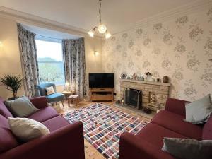 a living room with two purple couches and a fireplace at 3 Bed in Barnstaple 77506 in Bishops Tawton