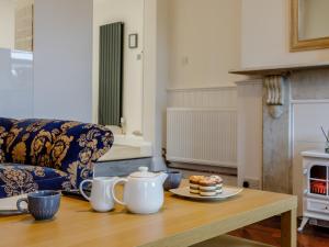 een woonkamer met een tafel met een theepot en cake bij 1 bed in Paignton 78200 in Paignton