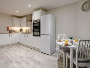 a kitchen with white cabinets and a white table and chairs at 1 bed in Paignton 78200 in Paignton