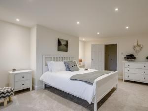 een witte slaapkamer met een groot bed en witte kasten bij 1 bed in Paignton 78200 in Paignton