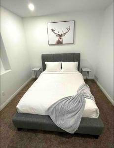 a bedroom with a bed with a deer picture on the wall at Relaxing 3 bedroom suite, near Silver Star Resort in Vernon