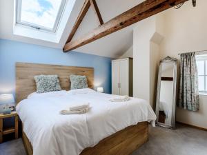 a bedroom with a large bed with a wooden headboard at 3 Bed in Wroxham 79211 in Dilham