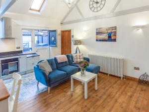 sala de estar con sofá azul y mesa en 2 Bed in Stibbard 79993 