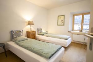 森特的住宿－Chasa Uina，一间卧室设有两张床、一盏灯和一扇窗户。