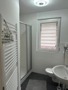 łazienka z umywalką, toaletą i oknem w obiekcie Anna´s Apartments w mieście Wiesbaden