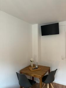 Pokój z drewnianym stołem i 2 krzesłami w obiekcie Anna´s Apartments w mieście Wiesbaden