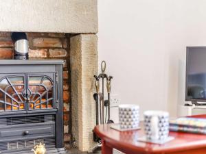 a fireplace in a living room with a table at 2 bed in Berwick Upon Tweed 81273 in Berwick-Upon-Tweed