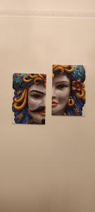 Tre dipinti di una donna su un muro di appartamento con charme centro storico ristrutturato a Trapani