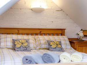 a bed with two pillows and towels on it at 1 Bed in Hay-on-Wye 81465 in Painscastle