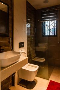 a bathroom with a sink and a toilet and a shower at Lakehouse Apartment - Lake Baikal - One Bedroom Apartment in Abuja
