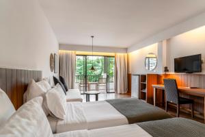 a hotel room with two beds and a television at Sunprime Kamala Beach in Kamala Beach