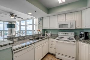 una cocina con armarios blancos y un horno de fogón blanco en Carolinian Beach Resort 1633, en Myrtle Beach