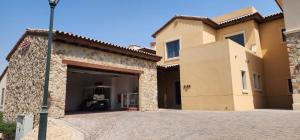 a large house with a garage in a driveway at Whispering Pines Jumeirah Golf Estates by Golden Casa in Dubai