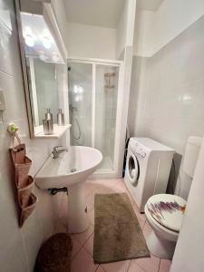 a bathroom with a sink and a washing machine at Suite bike with parking in Trieste +13 photos