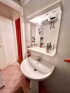 y baño con lavabo blanco y espejo. en Casa Bike in centro Trieste, en Trieste