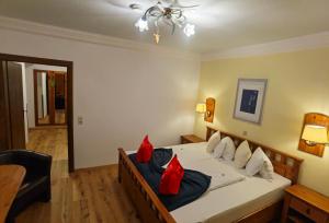 プレッセッガー・ゼーにあるHotel Kärntnerhof & SeeBlick Suitenのベッドルーム1室(赤い枕のベッド1台付)