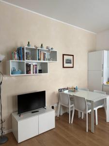 a white dining room with a table and a tv at Residenza Ca' Matta in Venice