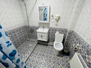 a bathroom with a toilet and a sink at Hotel Lola in Bukhara