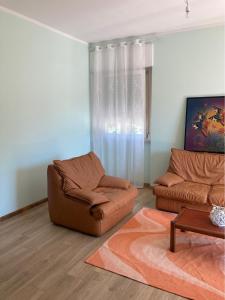 - un salon avec un canapé et une chaise dans l'établissement Appartamento P.zzale Tarducci, à Piobbico