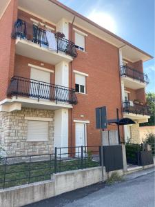 - un bâtiment en briques avec des balcons sur le côté dans l'établissement Appartamento P.zzale Tarducci, à Piobbico