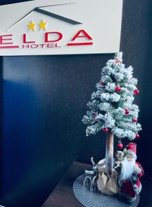 a miniature christmas tree with a santa claus at Hotel Elda in Bydgoszcz
